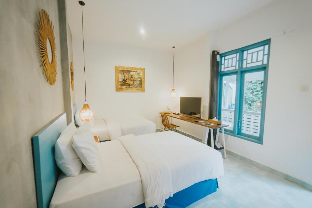 龙目岛库塔Birru Inn的一间卧室配有一张床、一张书桌和一个窗户。