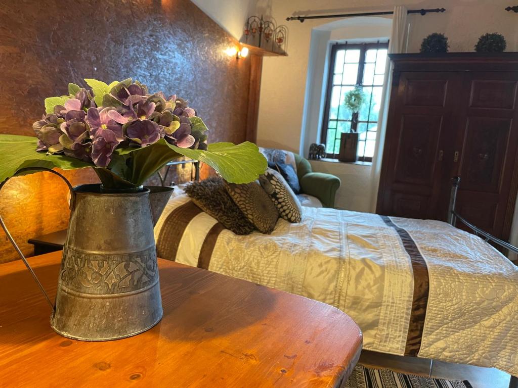 伦布尔克Studio Colonial的睡床旁边的桌子上花瓶