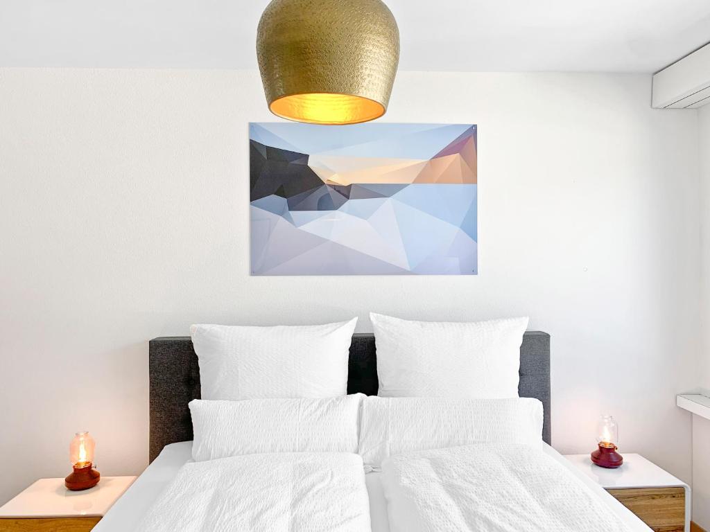 楚格ARISER - Mountain View Business Apartment的卧室配有一张床,墙上挂有绘画作品