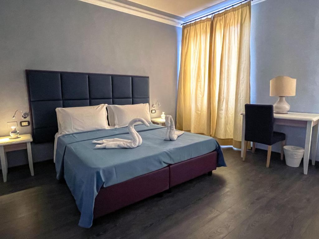 佛罗伦萨乔意亚酒店的一间卧室配有一张带两个天鹅的床