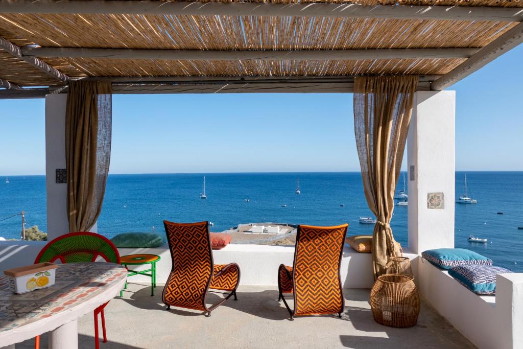 阿克罗蒂里Le Grand Blue Villa的一个带桌椅的庭院和大海