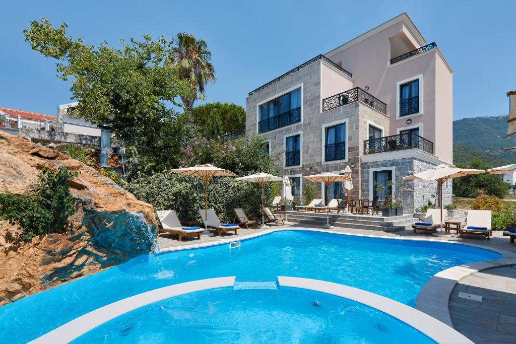 蒂瓦特Moderna Luxury Apartments with HEATED pool的一座别墅,在一座建筑前设有一个游泳池