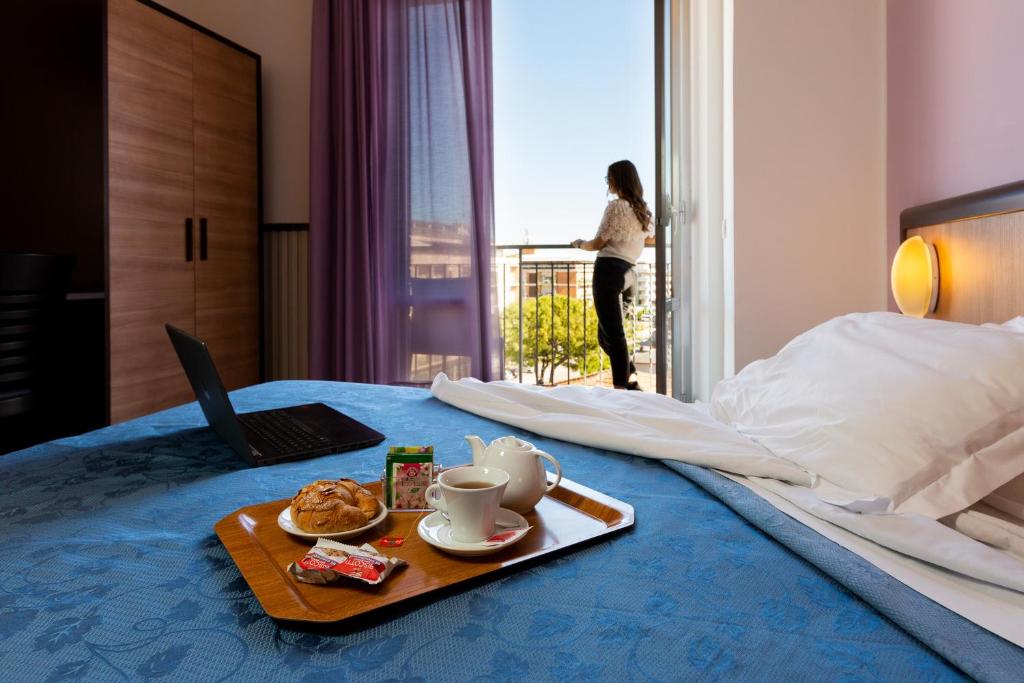 波尔图桑特埃尔皮迪奥观景台酒店的一张带食物托盘的床和一台笔记本电脑