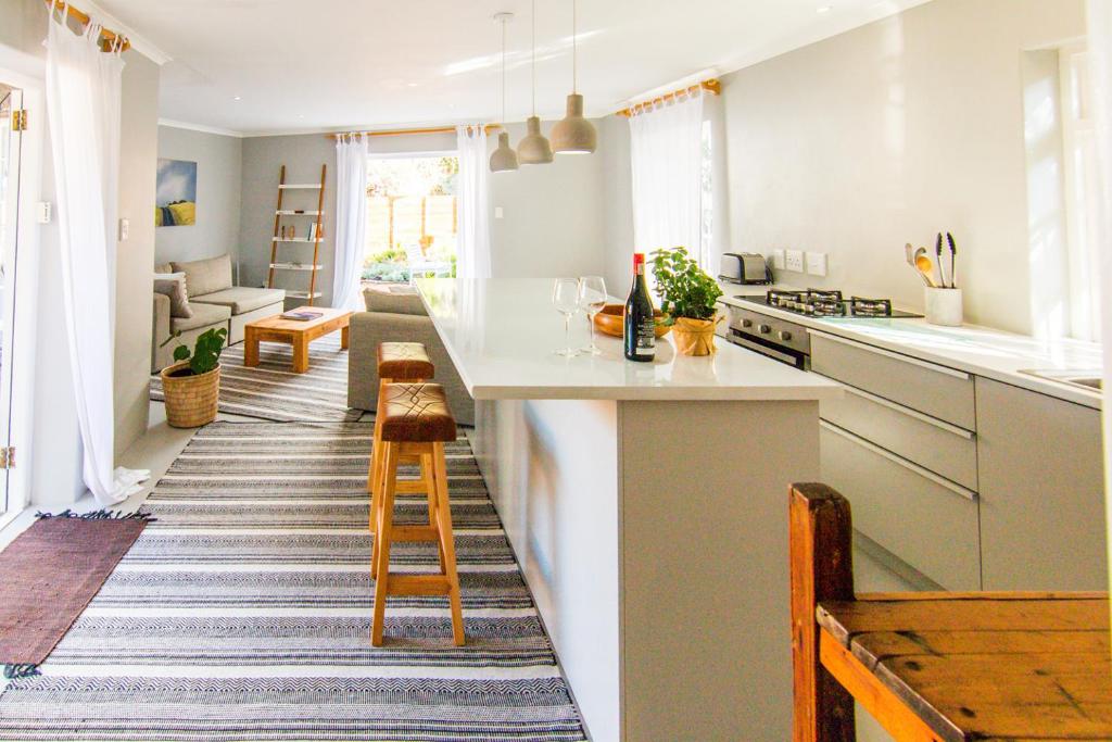 卡尔克湾Spacious and light Kalk Bay Garden Apartment的一间带白色台面的厨房和一间客厅