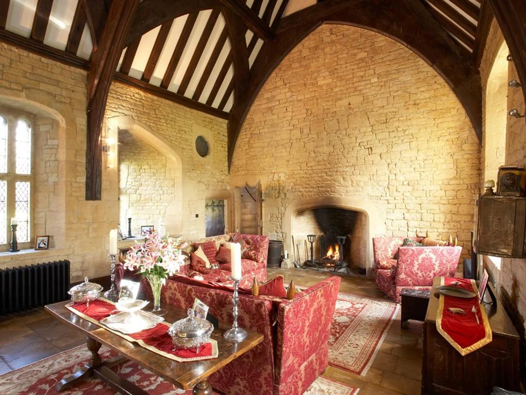 布罗德韦Abbots Grange Manor House的客厅设有红色的沙发和壁炉