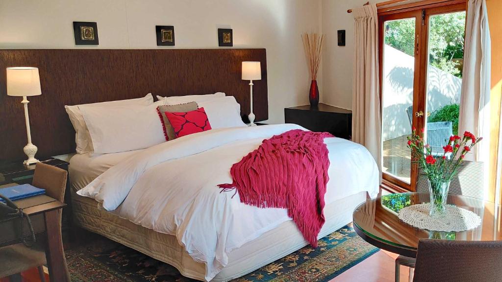 凯里凯里月亮门别墅酒店的一间卧室配有一张床铺,床上铺有红色毯子