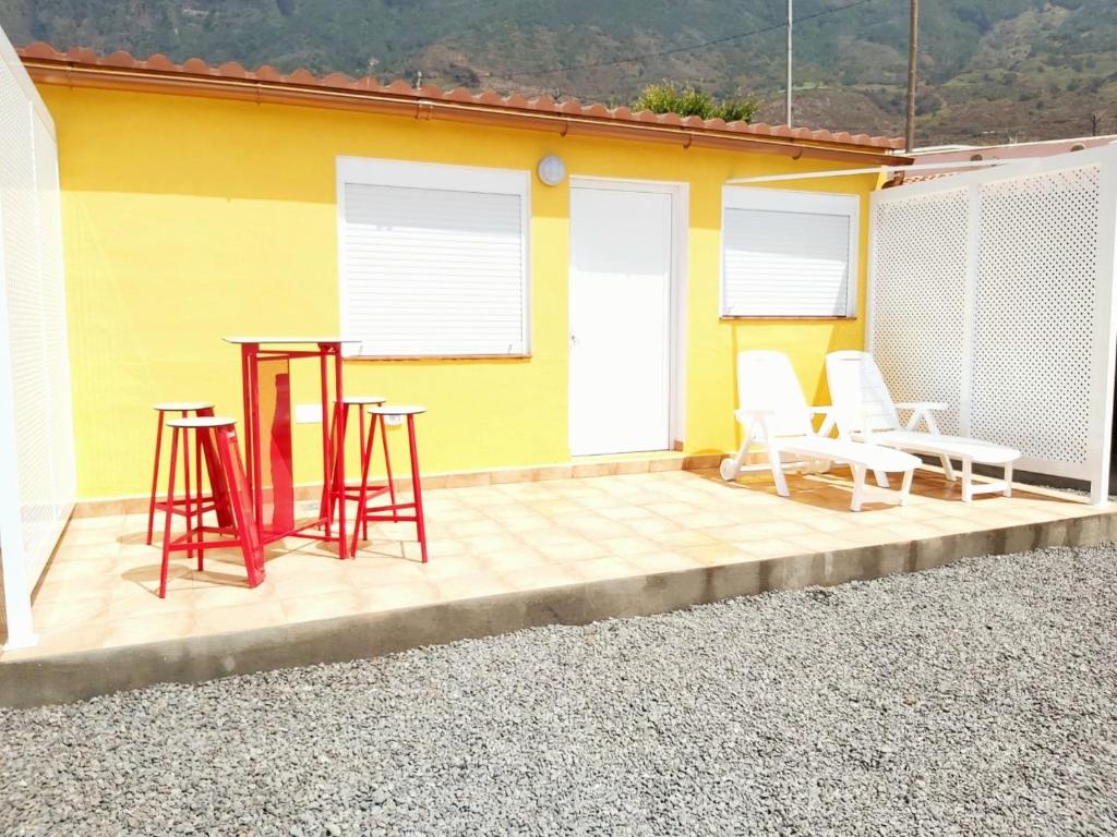 弗龙特拉Loft Con Encanto的一个带桌椅的庭院和一座黄色的房子