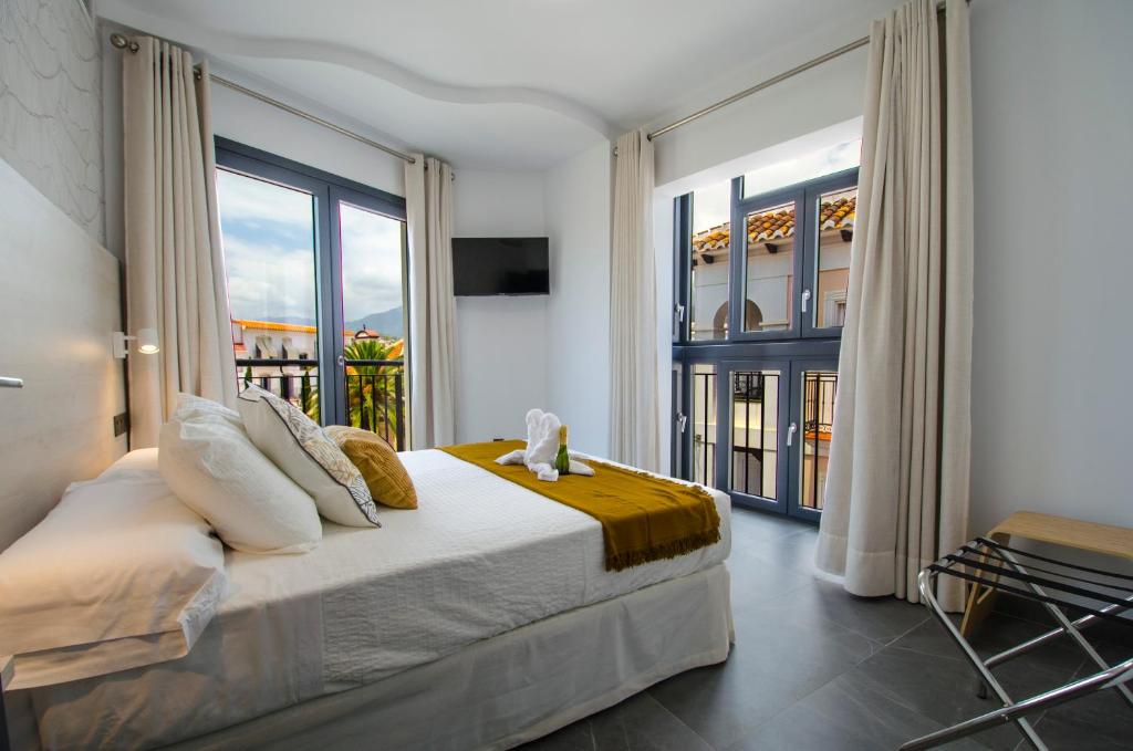 内尔哈NERJA-CENTRO-JACUZZI- MIRADOR DE LA ERMITA- Adults Recommended的一间卧室设有一张床和一个大窗户