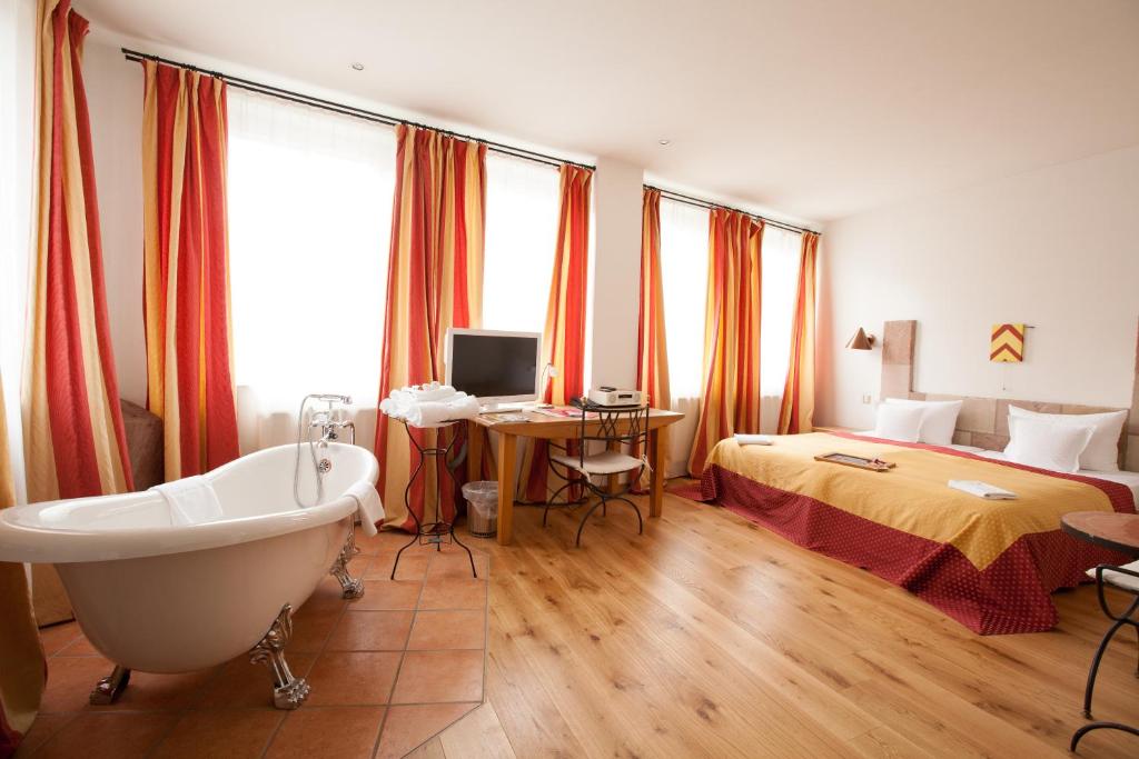 纽伦堡德尔瑞本酒店的带浴缸的浴室和1间带1张床的卧室