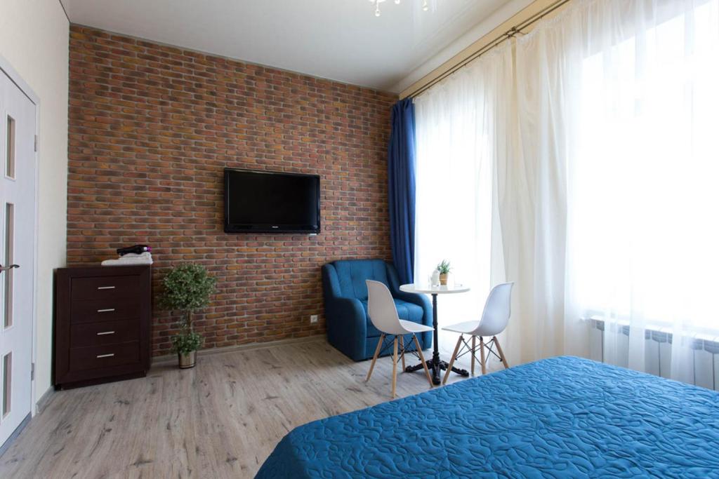 哈尔科夫Modern apartments in the Centre - Kuznechna str. 26/4的卧室配有1张床和1台砖墙电视