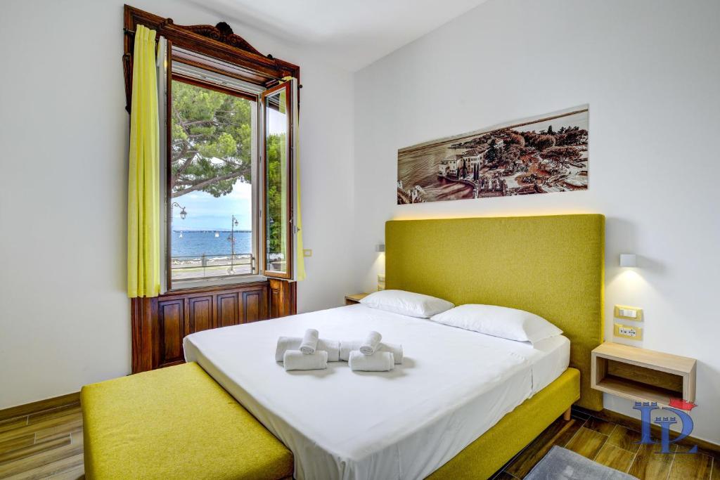 代森扎诺-德尔加达DesenzanoLoft Palazzo Visconti Luxury Suite的一间卧室设有一张大床和一个窗户。