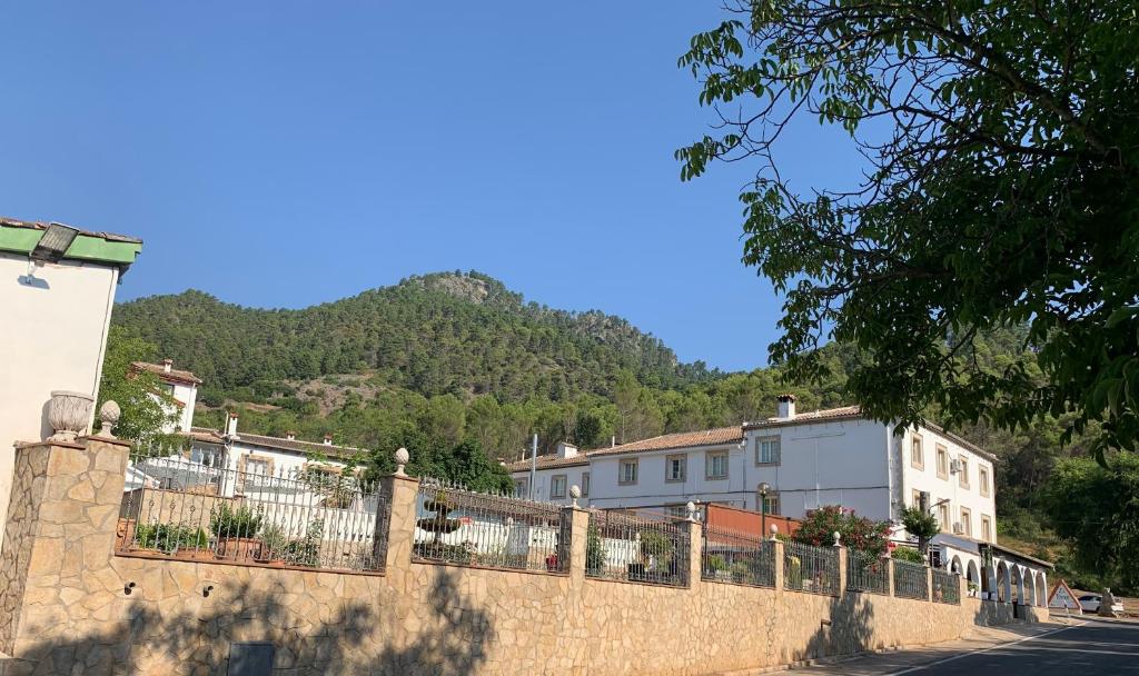 科托里奥斯米拉塞拉酒店的一座石墙,有房子,有山地背景