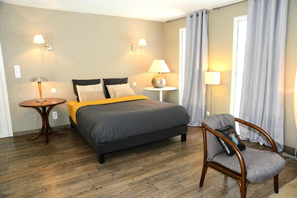 贝尔热拉克La Maison des Hérissons的一间卧室配有一张床、一把椅子和一张桌子
