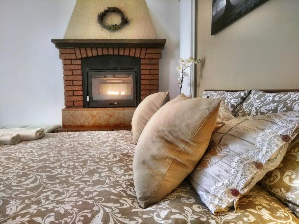 SalcedoCasa Ronzani B&B的一间卧室配有一张带枕头的床和壁炉