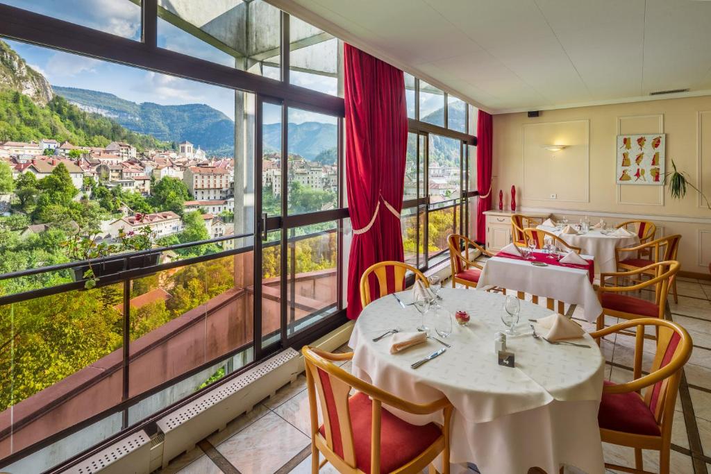 圣克洛德全景餐厅朱拉酒店的餐厅设有桌椅和大窗户。