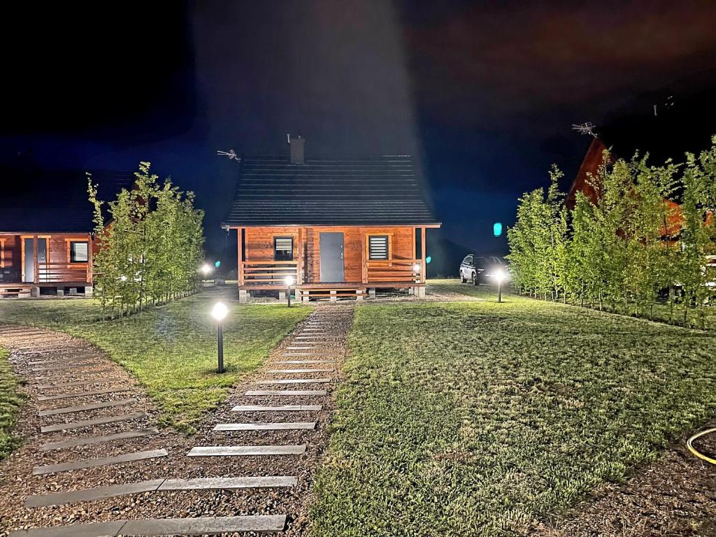 厄尔科Domki Mazurskie Zacisze Jeziora Sunowo的夜间在院子里灯火通明的小木屋