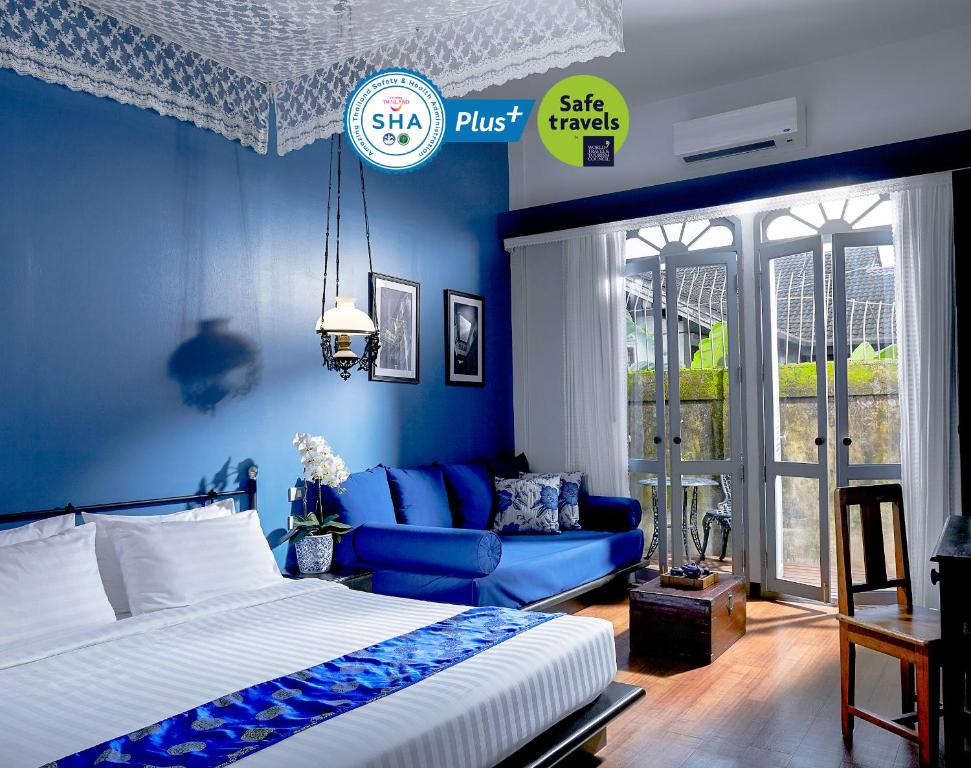 普吉镇The Memory at On On Hotel的蓝色的卧室配有床和沙发