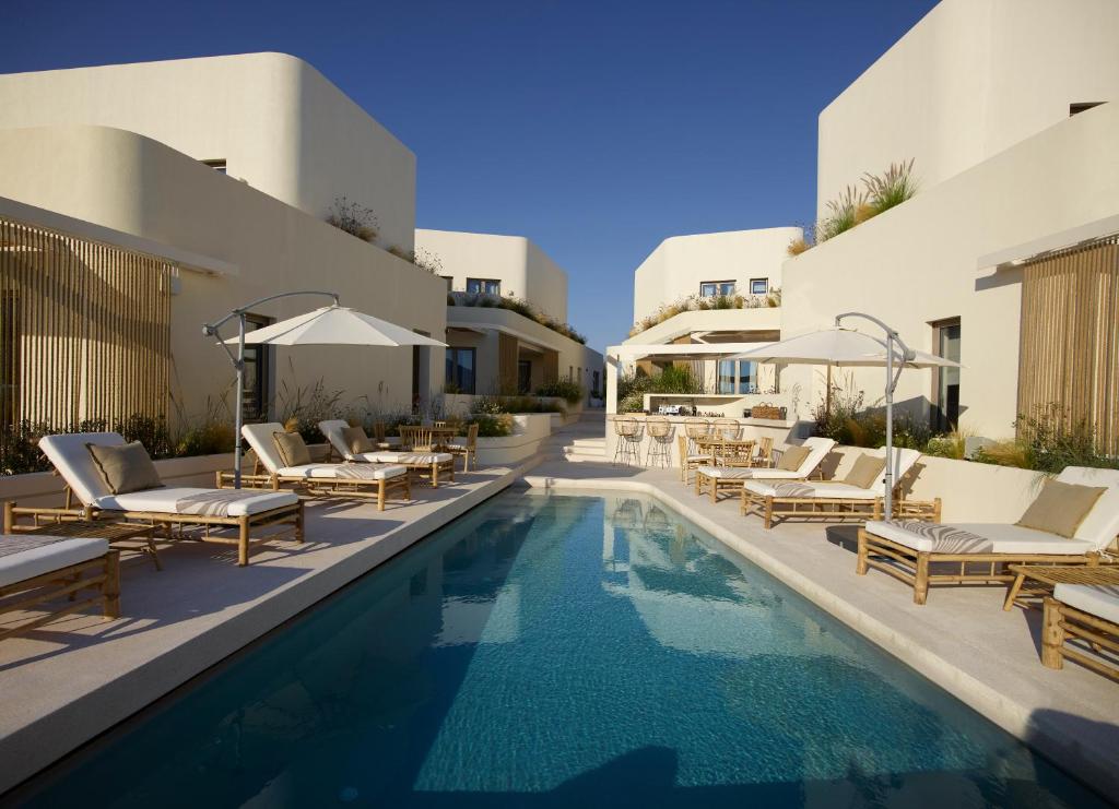 阿波罗尼亚White Pebble Suites的一个带躺椅的游泳池和一间酒店