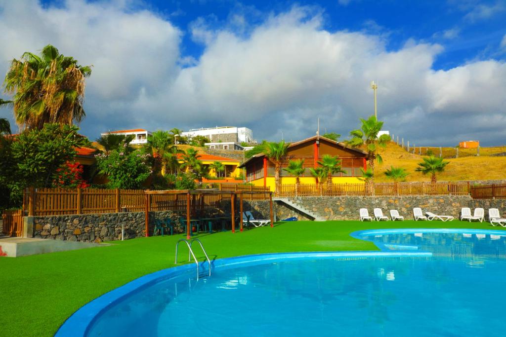 圣菲利佩Hotel Casas do Sol的设有一个大型游泳池和绿草的度假胜地