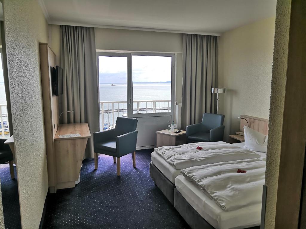 萨斯尼茨Rügen-Hotel的酒店客房设有一张床,享有海景。