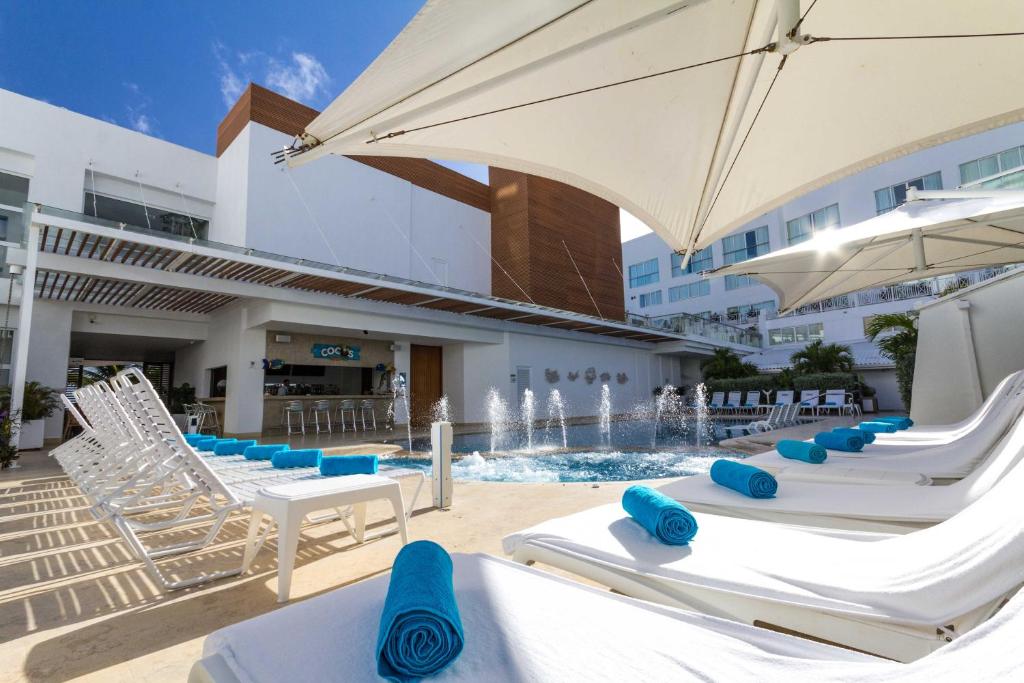圣安德烈斯卡萨布兰卡酒店的一组椅子和遮阳伞,位于游泳池旁