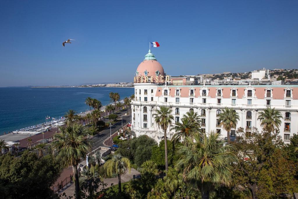 尼斯Hotel Le Negresco的一座顶部有圆顶的建筑,靠近大海