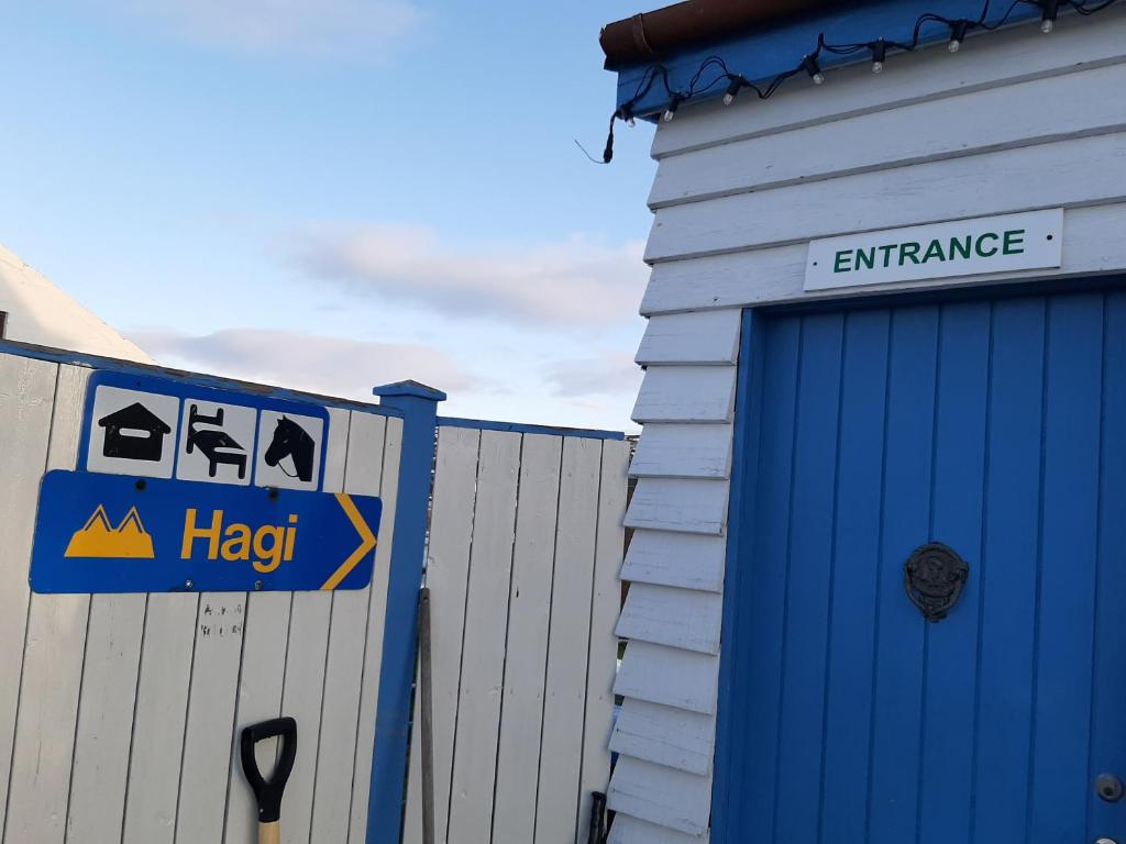 AðaldalurHagi 1 Guesthouse的车库旁的一座带帮助标志的建筑