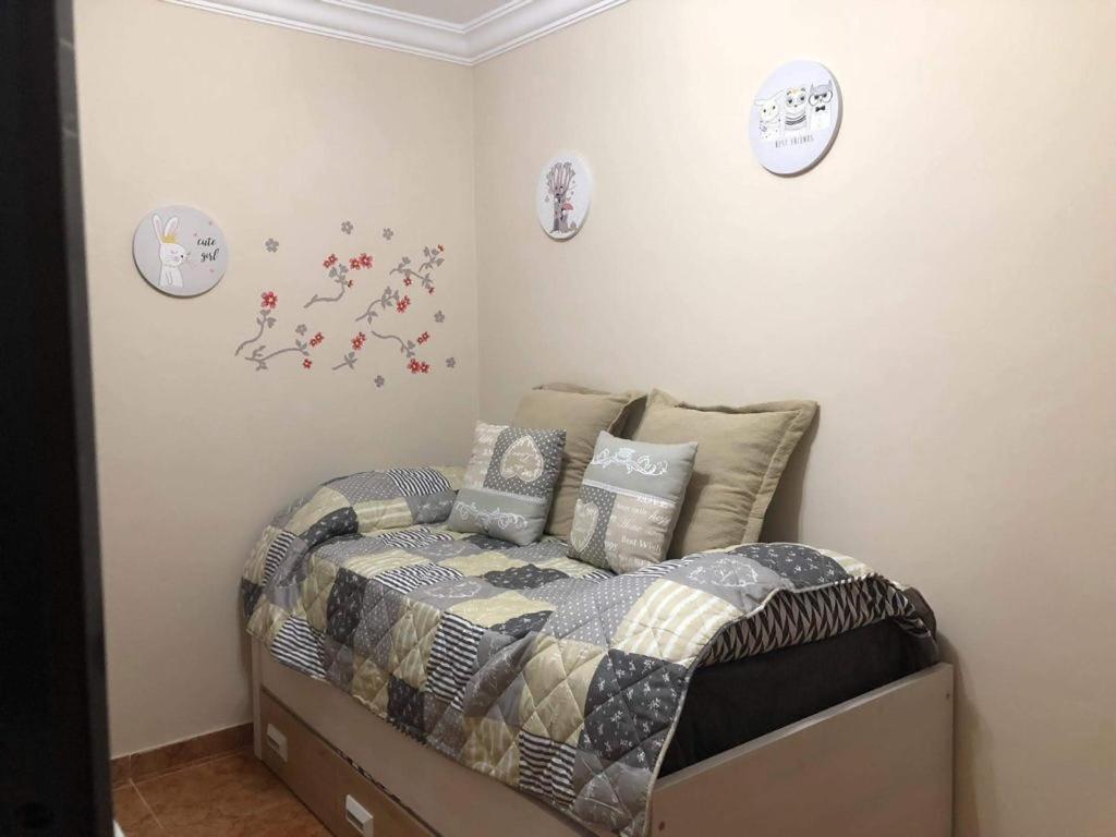 大加那利岛拉斯帕尔马斯LAS CANTERAS的卧室配有床和墙上的时钟