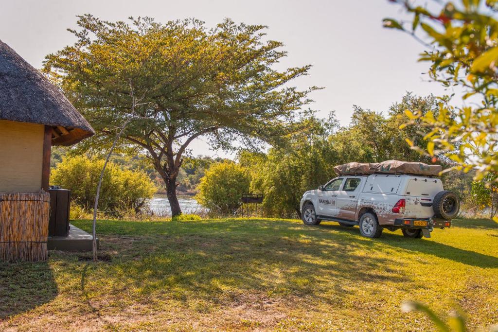 龙杜Hakusembe River Campsite的停在房子旁边的院子中的一辆白色卡车