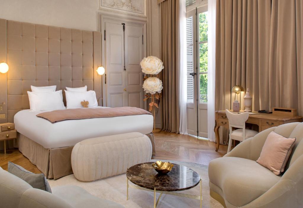 蒙彼利埃Hôtel Richer De Belleval - Relais & Châteaux的一间卧室设有一张床和一间客厅。