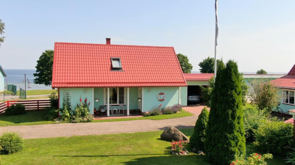 凯尔德拉Mere kodumajutus的一座红色屋顶的房子和一个院子