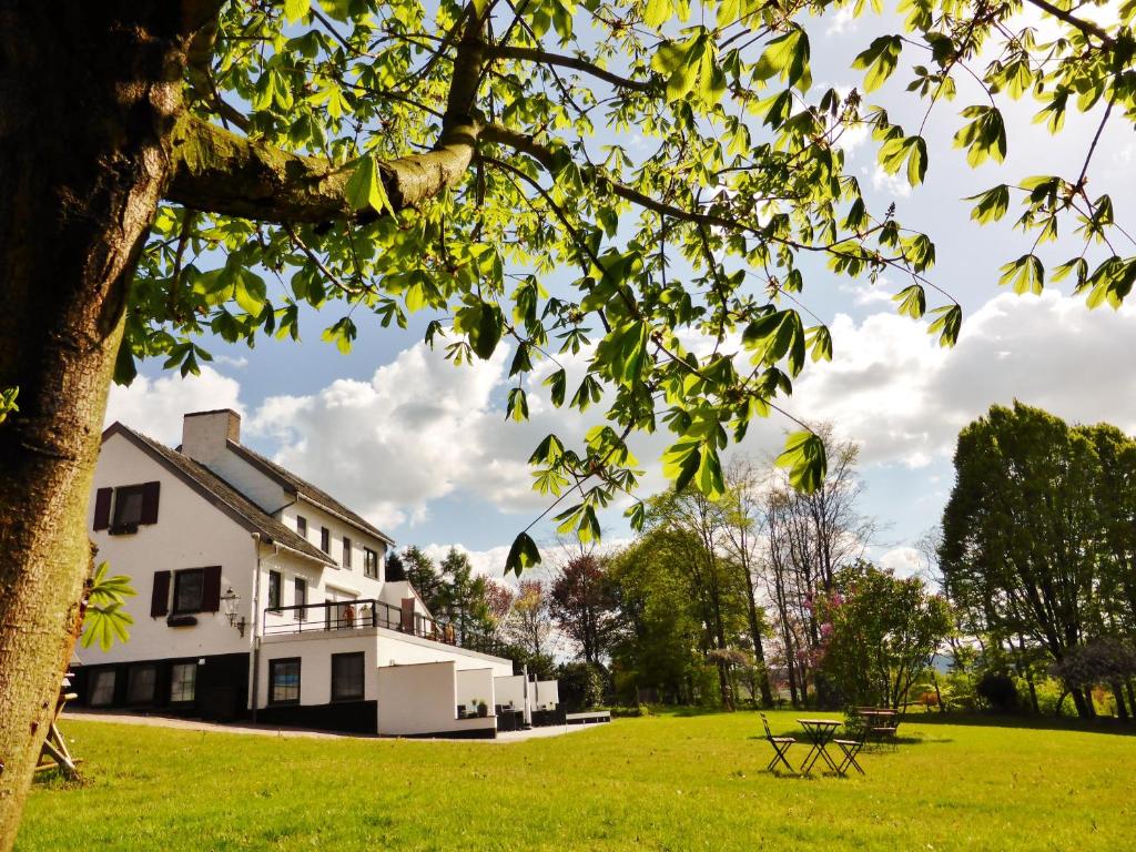 梅赫伦Villa Witte Lelie的一座白色的大建筑,在田野上设有野餐桌