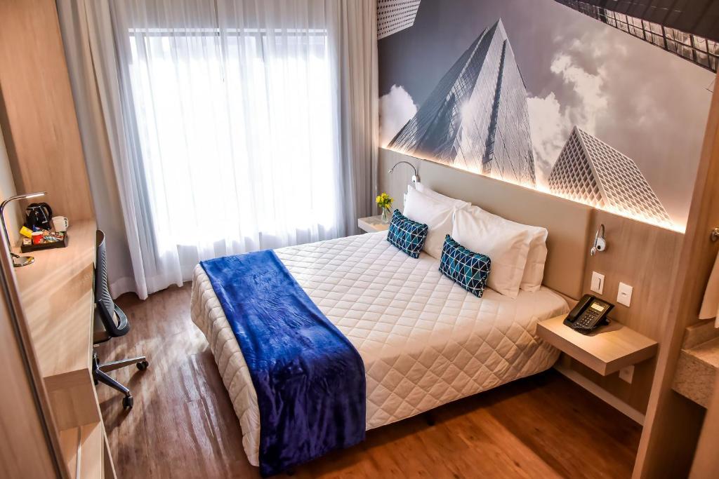 圣保罗Rio Hotel by Bourbon São Paulo Barra Funda的一间卧室配有一张带蓝色毯子的床