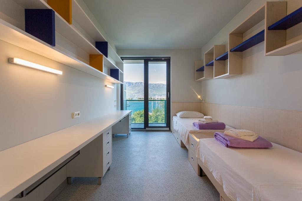 斯普利特Hostel BB的客房设有三张床和一张带窗户的书桌