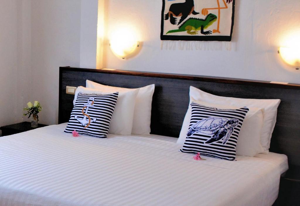 阿约拉港卡皮滩麦克斯住宿加早餐旅馆的卧室配有白色的床和黑白色枕头