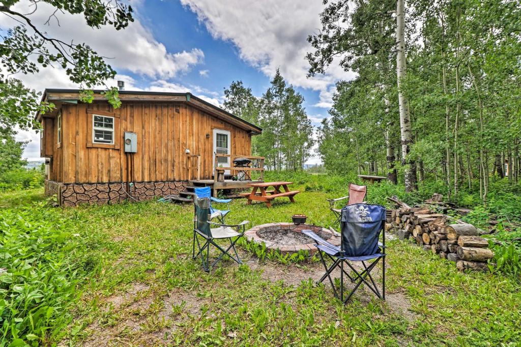 圣玛丽Duck Lake Cabin Rental Near Glacier National Park!的树林中的小屋,配有椅子和火坑