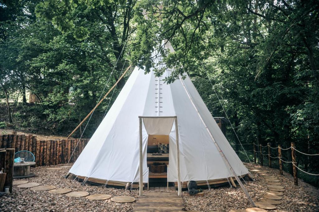 UnhošťGlamping Nad Meandry的森林中央的白色帐篷