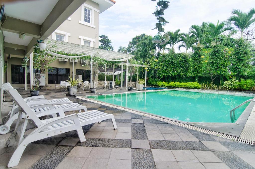 泗水Country Heritage Hotel的一个带两把白色椅子的游泳池