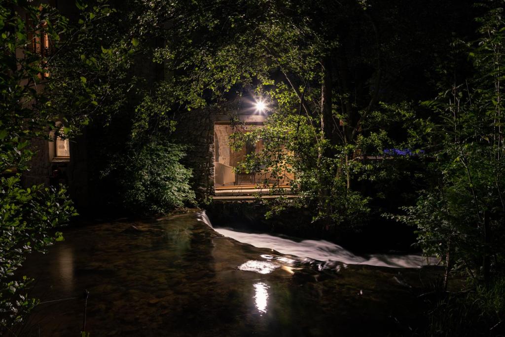 Bourg-ArgentalLa chapelle moulin traversée par l'eau jacuzzi piscine classé 5 étoiles的夜晚窗户上灯的房子