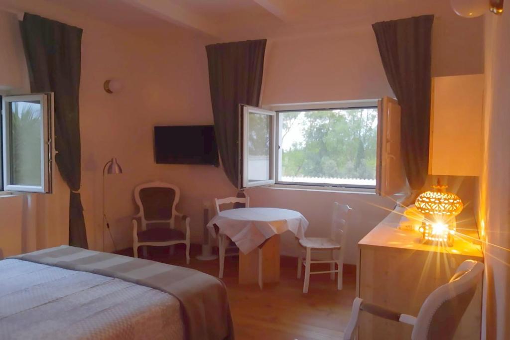IppocampoHenry Agriturismo Manfredonia的酒店客房设有床、桌子和窗户。