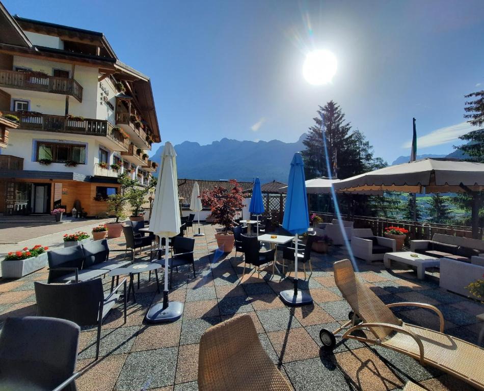 莫埃纳Monza Dolomites Hotel的一组桌椅和遮阳伞
