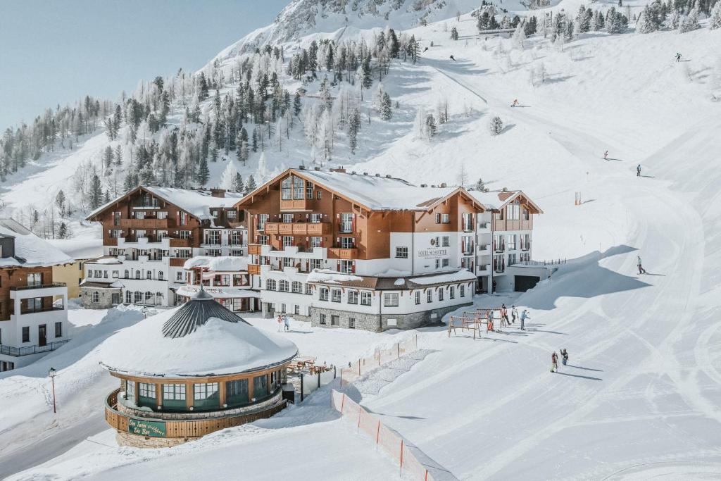 上陶恩Superior Hotel Schneider Ski-in & Ski-out的雪地中的滑雪小屋,有雪覆盖的建筑