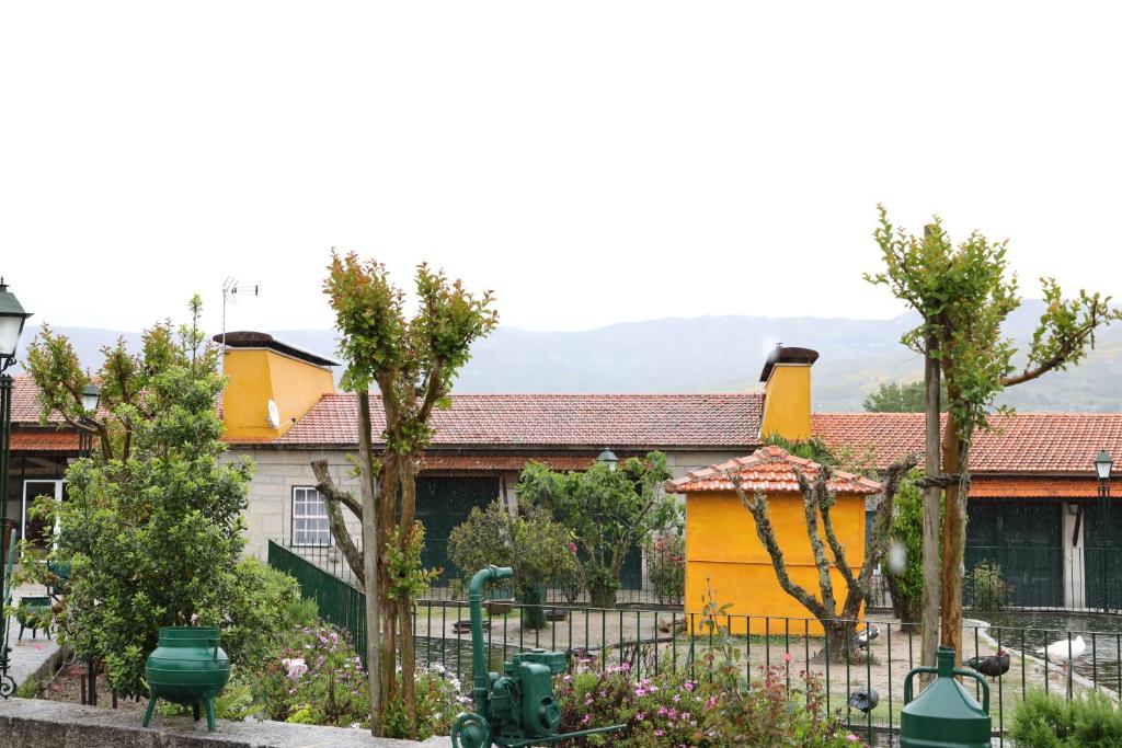 皮年索斯Quinta dos Patos的黄色房子,有栅栏和树木