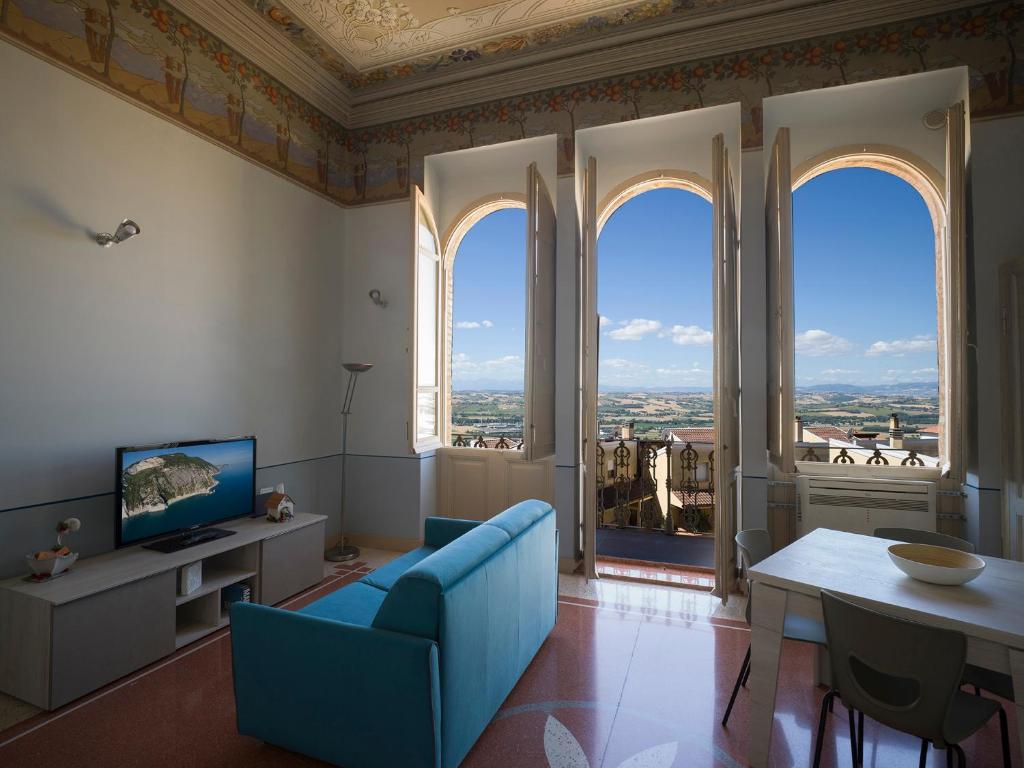 卡斯泰尔菲达尔多ROSSO DI SERA的客厅设有蓝色的沙发和大窗户
