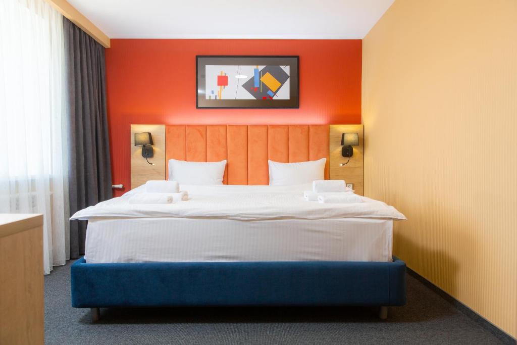 科克舍套Отель KOKSHETAU的一间卧室配有一张带橙色墙壁的大床