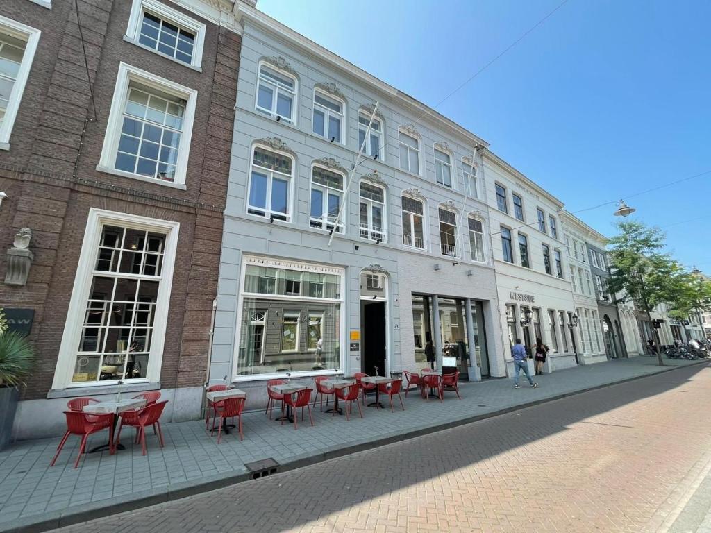 登博斯Bossche Suites No2 - Verwersstraat的街上有红色桌椅的建筑