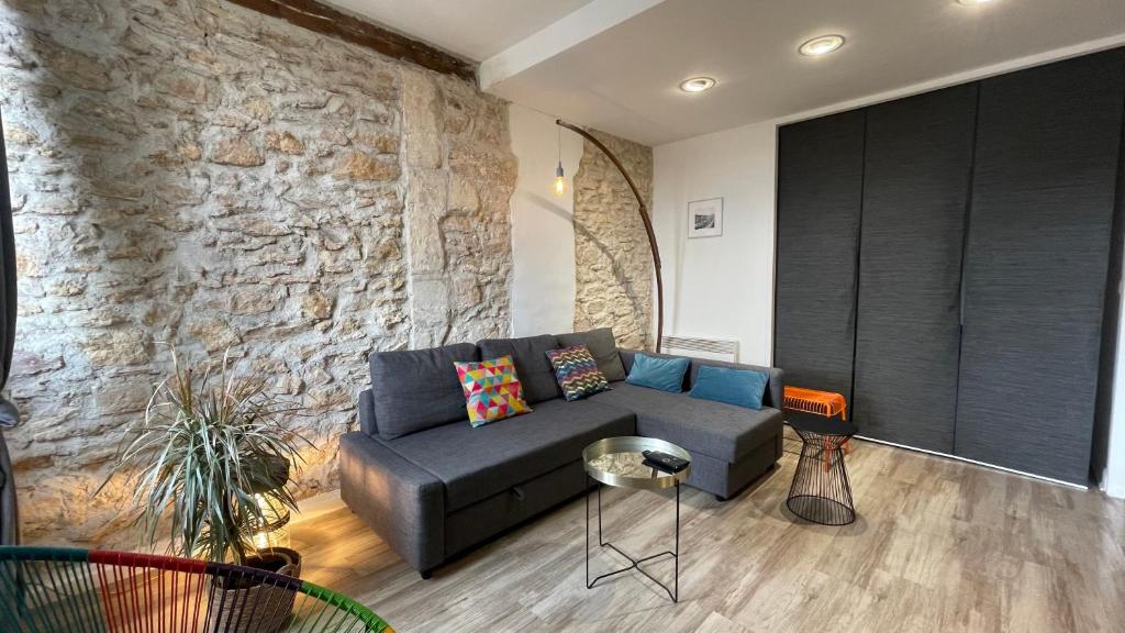 马赛Appartement Hyper Centre-Vieux Port-Place aux Huiles的带沙发和石墙的客厅