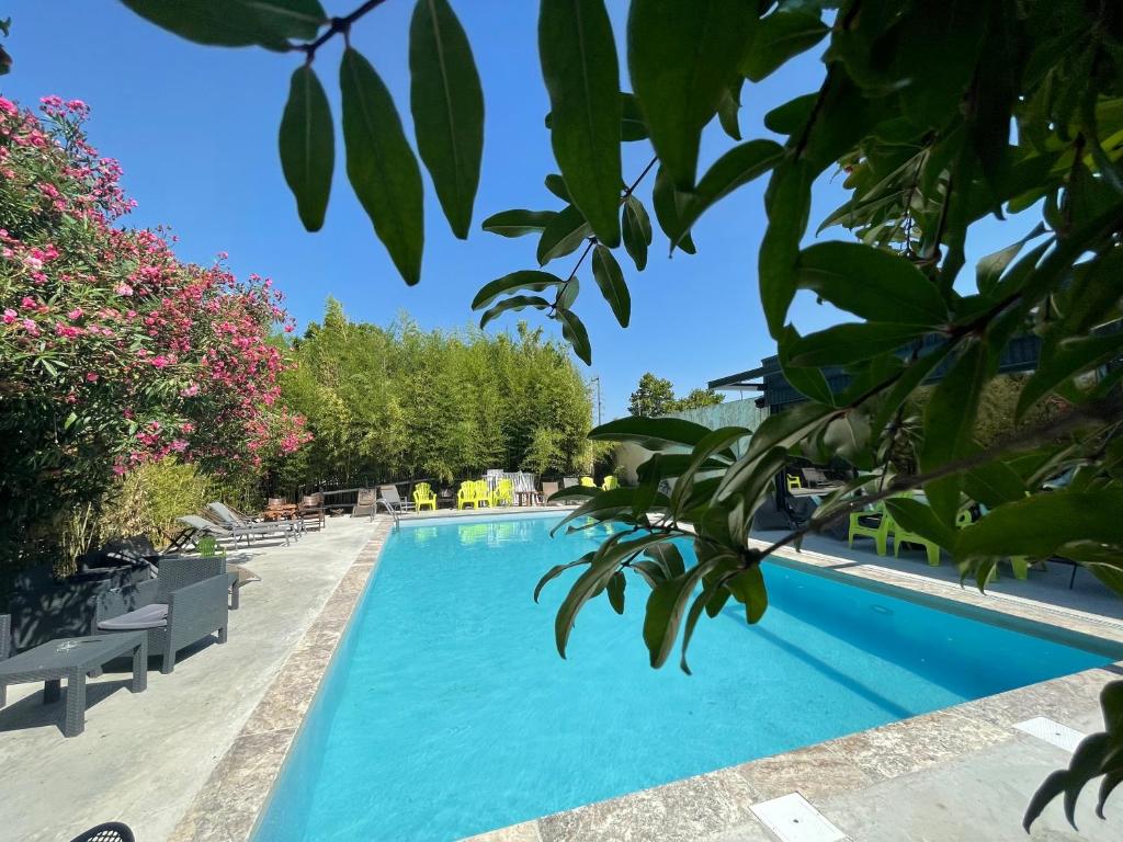 尼姆Logis NIMOTEL Hôtel Cosy的拥有蓝色海水和树木的游泳池