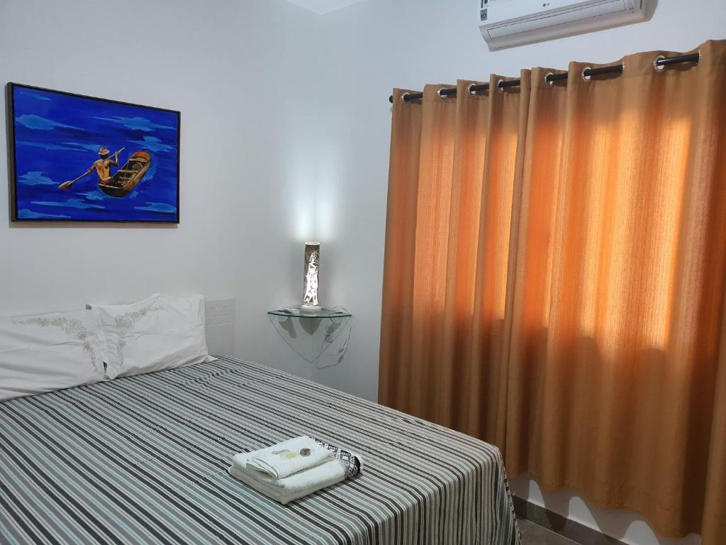 库亚巴Suite 03 - Independente, privativa e aconchegante的一间卧室配有一张床和浴帘
