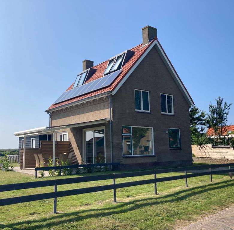 霍勒姆Vissers Huus Hollum Ameland的屋顶上设有太阳能电池板的房子